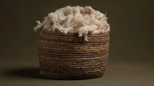 Amarae natural kapok pillow filling displayed in a woven basket for adjustable comfort and supportive sleep.